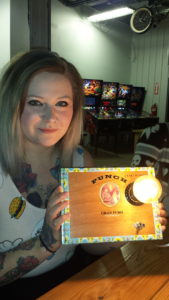 A participant holds up her cigar box lamp creation.