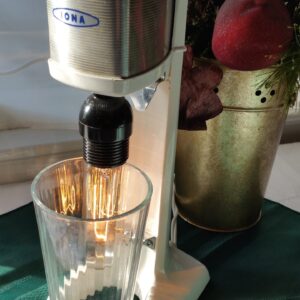 This lamp is aptly called "Shake 'Em Up" and features a vintage shake maker with cream finish and metallic accents. But where she really shines (pun alert) is when her accompanying pint glass diffuses the light in a hundred different directions.