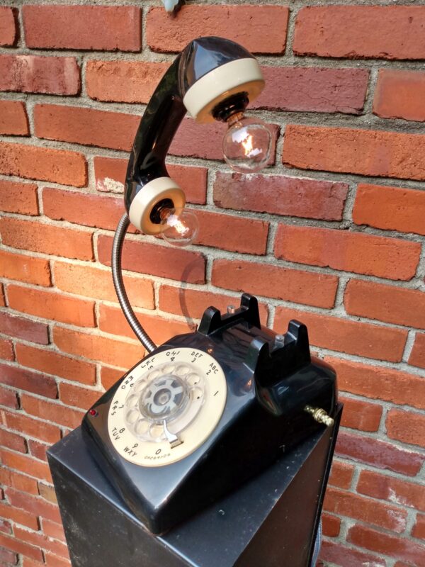 A two-woned cream and black vintage telephone that has two light bulbs coming out of the reciever handle. It's the perfect Wedding Gift!