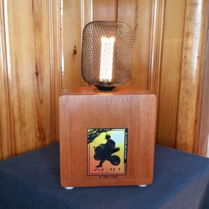This Acid Motorcycle Lover Lamp is carefully crafted from an Acid cigar box with cool and colorful motorcycle graphics. Topped with an industrial black wire cage around the pillar style LED light.